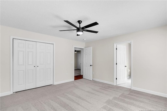 unfurnished bedroom with a closet, a textured ceiling, baseboards, and carpet floors