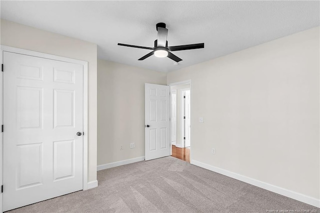 unfurnished bedroom featuring carpet flooring, a ceiling fan, and baseboards