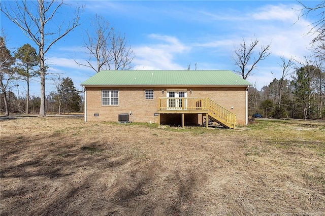 rear view of house featuring crawl space, cooling unit, stairs, and brick siding