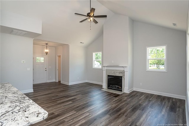 5814 James Allen Ln, Stedman, NC 28391 - unfurnished living room with a high end fireplace, high vaulted ceiling, dark wood finished floors, ceiling fan, and a chandelier