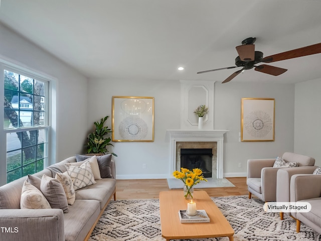 living area featuring a ceiling fan, wood finished floors, recessed lighting, a fireplace, and baseboards