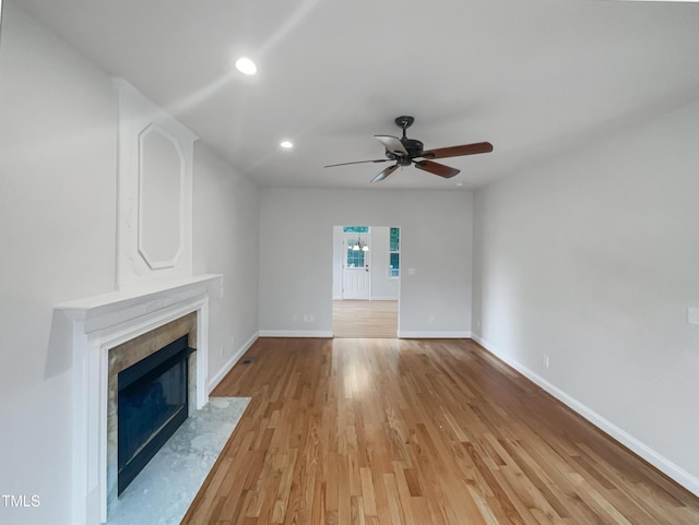 unfurnished living room with light wood-style flooring, recessed lighting, a fireplace, baseboards, and ceiling fan