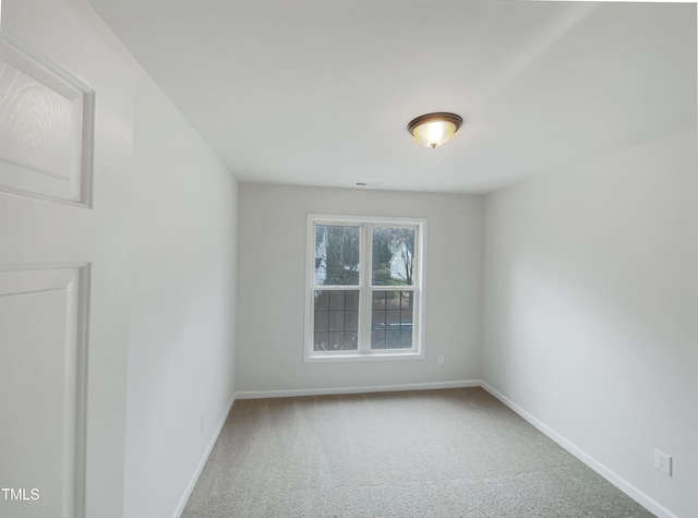 carpeted spare room featuring baseboards