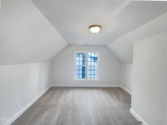 additional living space with carpet flooring, lofted ceiling, and baseboards