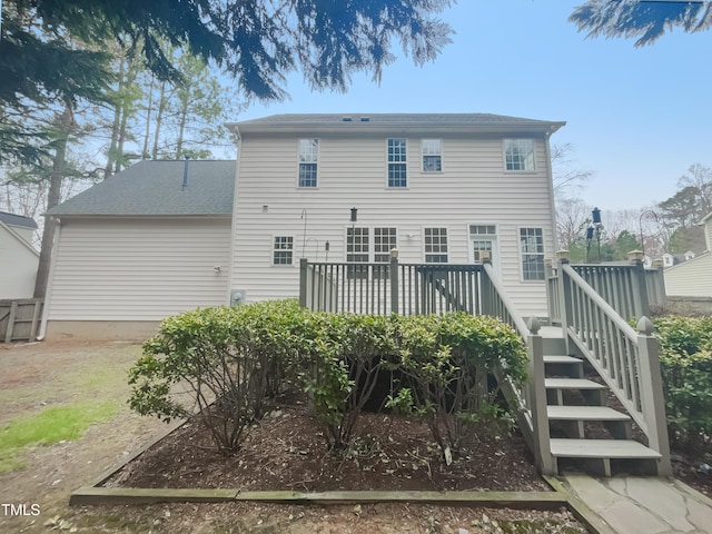 rear view of house with a wooden deck and a shingled roof