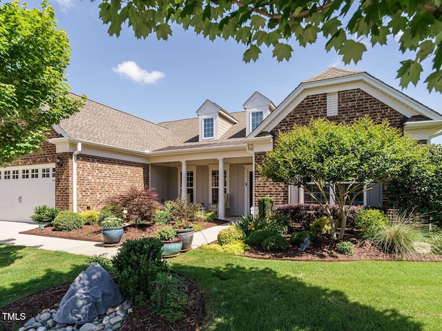 view of front of home with brick siding, an attached garage, and a front yard