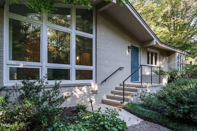 view of exterior entry with brick siding