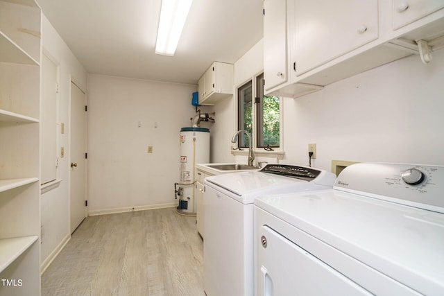 clothes washing area with gas water heater, light wood-type flooring, cabinet space, and washer and clothes dryer