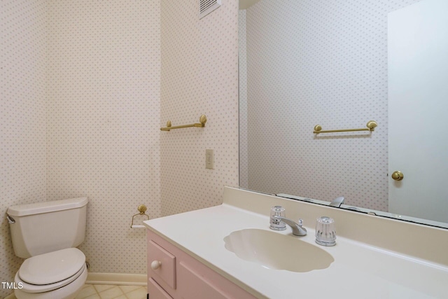 half bathroom with tile patterned floors, visible vents, toilet, and vanity