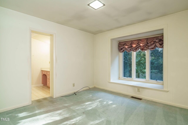 empty room with visible vents, baseboards, and carpet