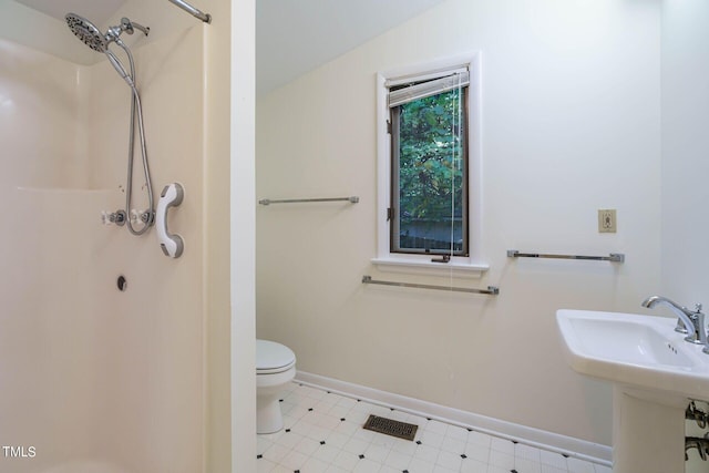 bathroom with tile patterned floors, toilet, a shower, and baseboards