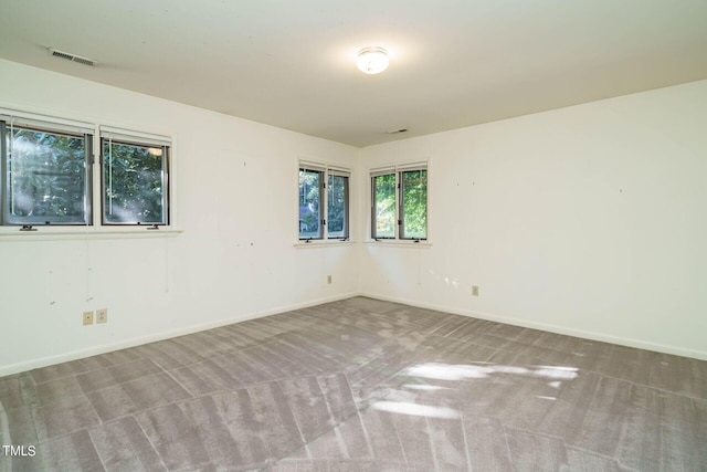 carpeted empty room with visible vents and baseboards