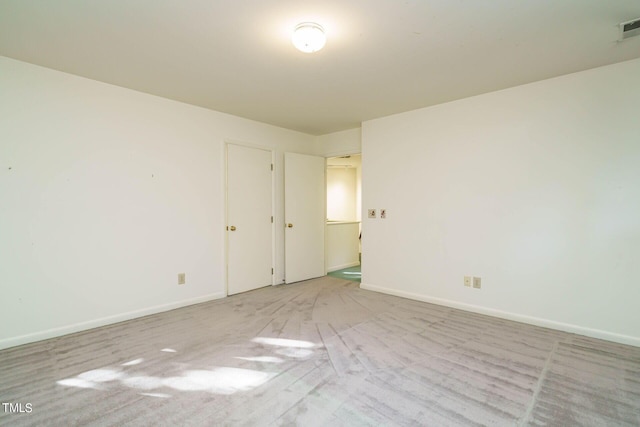 unfurnished room featuring visible vents and baseboards