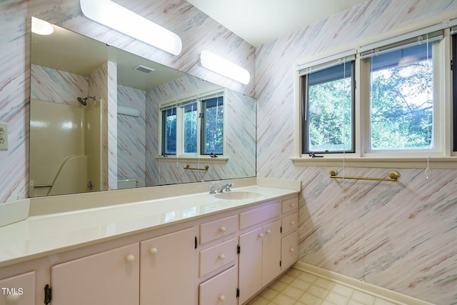 full bath featuring vanity, a shower, visible vents, and wallpapered walls