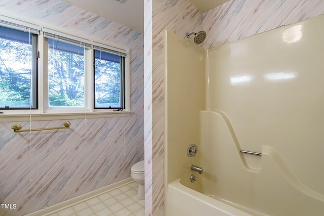 full bath featuring toilet, bathing tub / shower combination, and tile patterned flooring