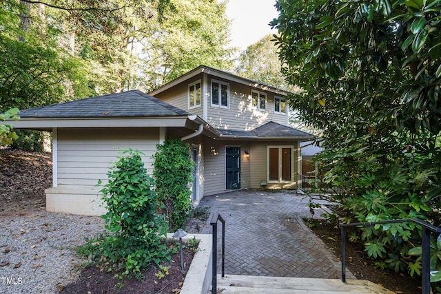 view of front of house featuring a patio area and roof with shingles