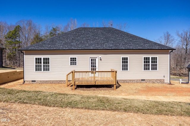 rear view of property featuring a wooden deck, roof with shingles, and crawl space