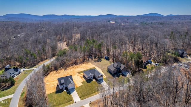 birds eye view of property featuring a view of trees and a mountain view