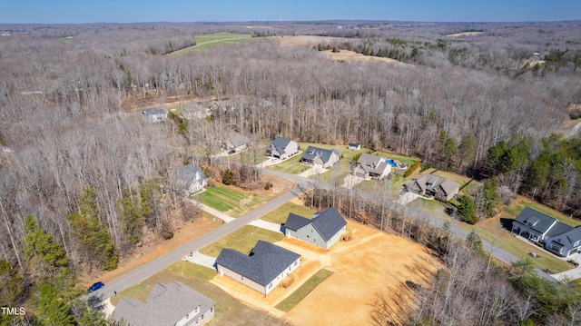 drone / aerial view featuring a wooded view