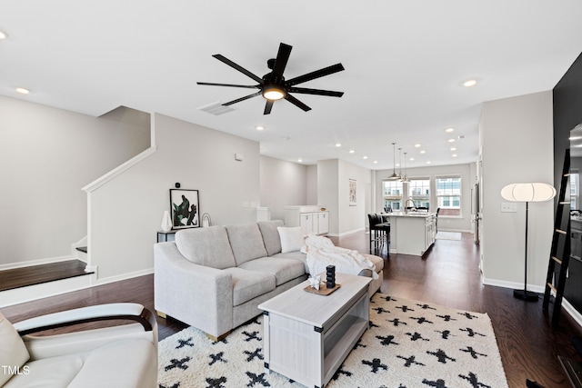 living area featuring visible vents, baseboards, stairway, recessed lighting, and dark wood-style flooring