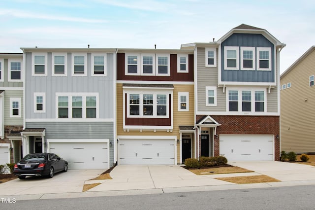 multi unit property featuring a garage, board and batten siding, and driveway