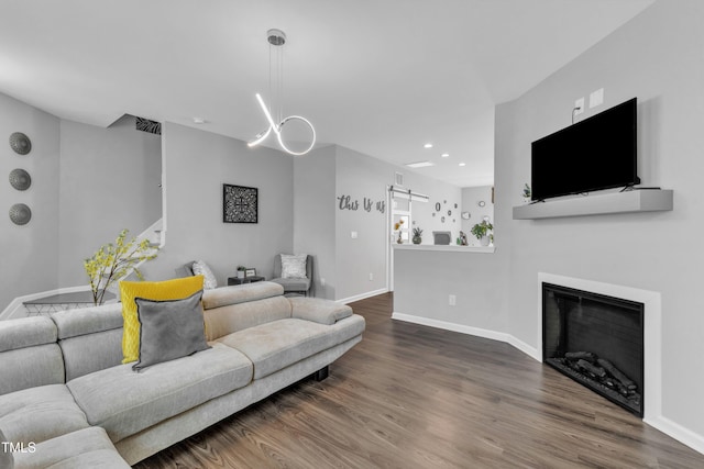 living area with wood finished floors, visible vents, baseboards, recessed lighting, and a glass covered fireplace