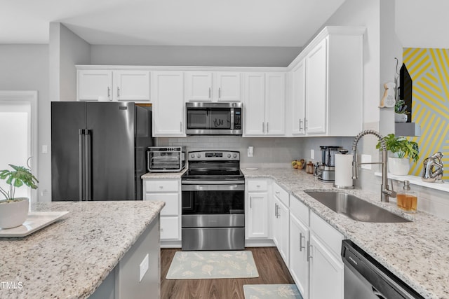 kitchen featuring a sink, stainless steel appliances, dark wood finished floors, and white cabinets