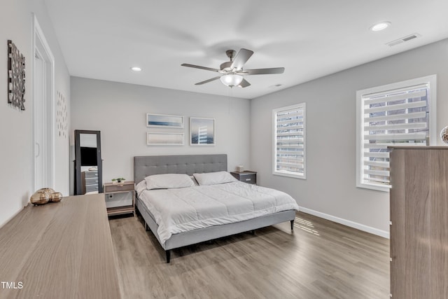 bedroom featuring visible vents, a ceiling fan, wood finished floors, recessed lighting, and baseboards