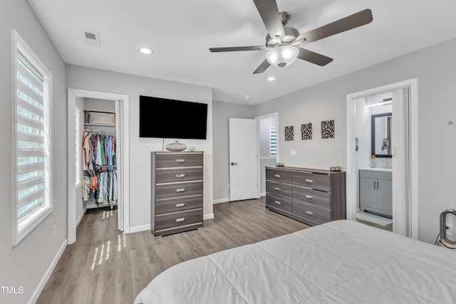 bedroom with visible vents, multiple windows, wood finished floors, and a spacious closet