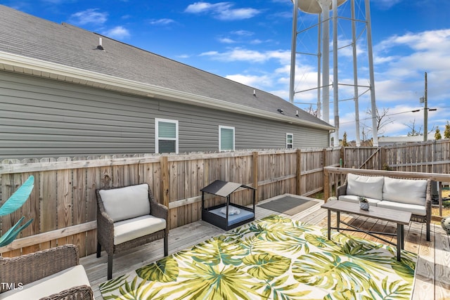 wooden terrace with an outdoor hangout area and a fenced backyard