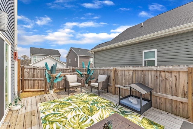 wooden terrace featuring an outdoor living space and fence