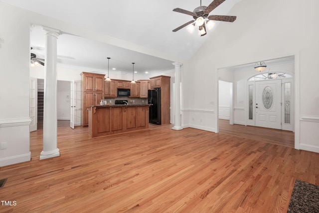 unfurnished living room with a ceiling fan, light wood finished floors, high vaulted ceiling, ornate columns, and ornamental molding