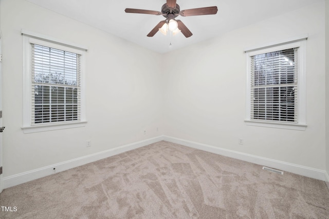 empty room featuring visible vents, baseboards, carpet, and a ceiling fan