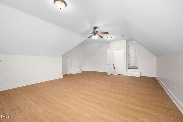 additional living space featuring baseboards, a ceiling fan, vaulted ceiling, and light wood finished floors