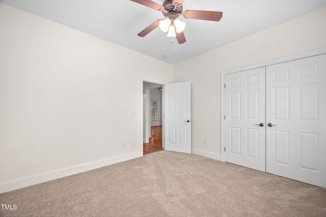 unfurnished bedroom with a closet, baseboards, a ceiling fan, and carpet flooring