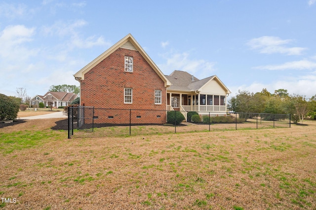 back of property with fence, a yard, a sunroom, crawl space, and brick siding