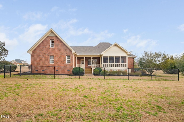 rear view of property featuring crawl space, brick siding, a lawn, and a sunroom