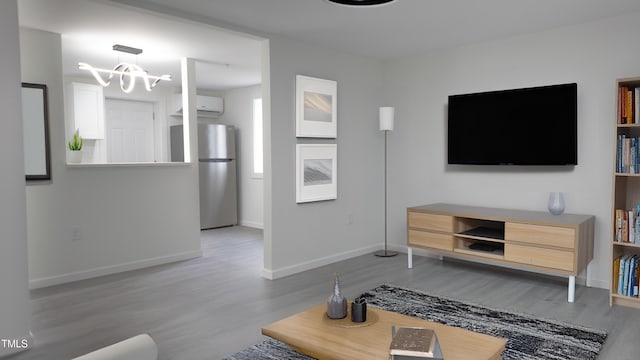 800 Pritchard Avenue Extension Unit H3, Chapel Hill, NC 27516 - living room with wood finished floors, a chandelier, baseboards, and a wall unit AC