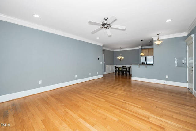 unfurnished living room with ceiling fan with notable chandelier, baseboards, crown molding, and light wood-style floors