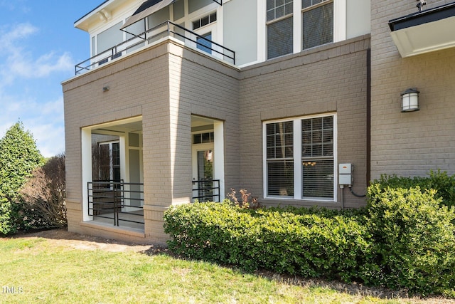 entrance to property with a balcony and brick siding