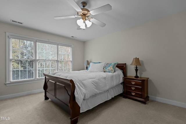 bedroom with baseboards, visible vents, and light carpet