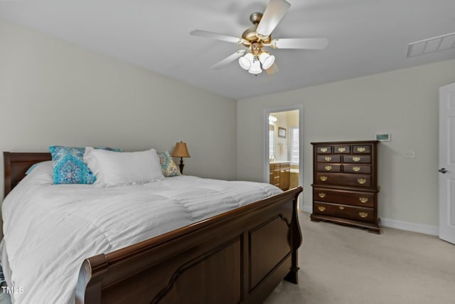 bedroom with visible vents, ensuite bathroom, a ceiling fan, baseboards, and light colored carpet