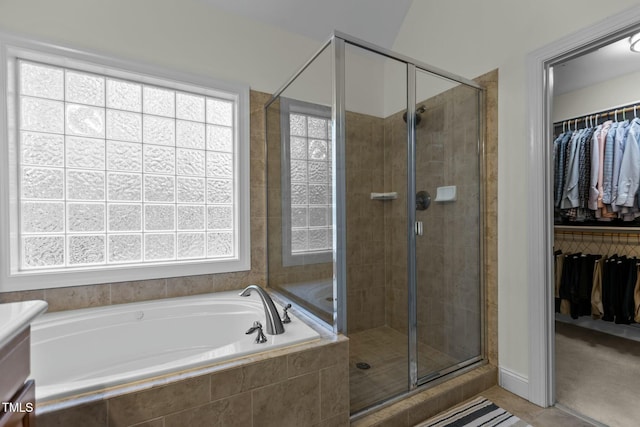 full bath with a walk in closet, a shower stall, a garden tub, and vanity