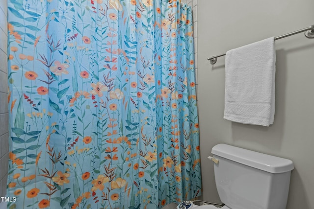 full bath featuring toilet and a shower with shower curtain