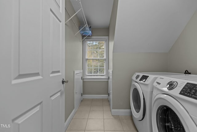 washroom with light tile patterned floors, laundry area, independent washer and dryer, and baseboards