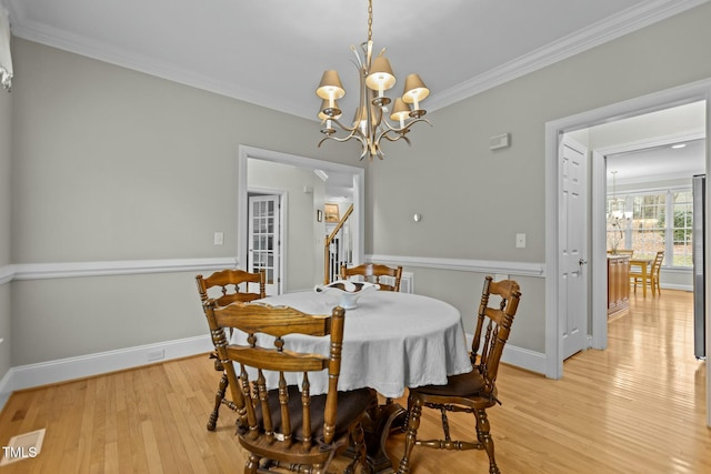 dining space featuring an inviting chandelier, baseboards, light wood-type flooring, and ornamental molding