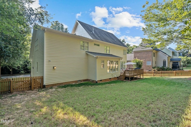 rear view of property featuring crawl space, a lawn, a wooden deck, and fence