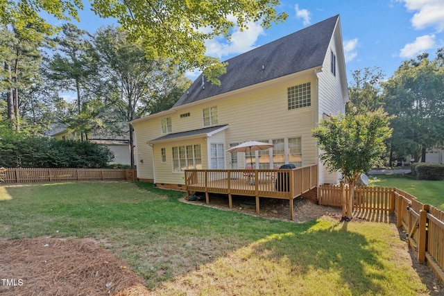 rear view of house with a yard, a deck, a fenced backyard, and roof with shingles