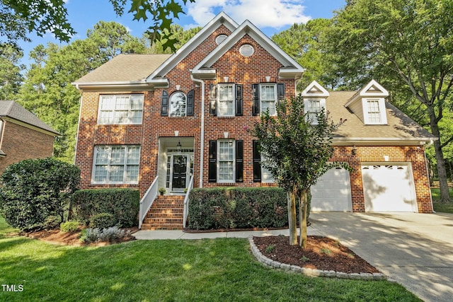 colonial home featuring brick siding, driveway, a front lawn, and a garage