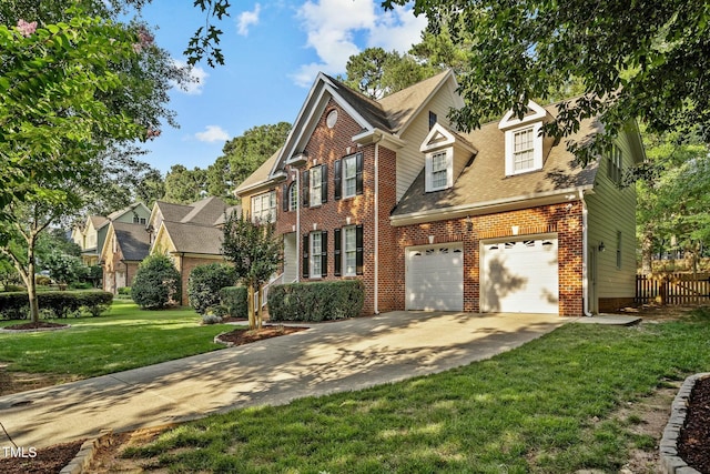 view of front facade with a front yard, fence, driveway, an attached garage, and brick siding